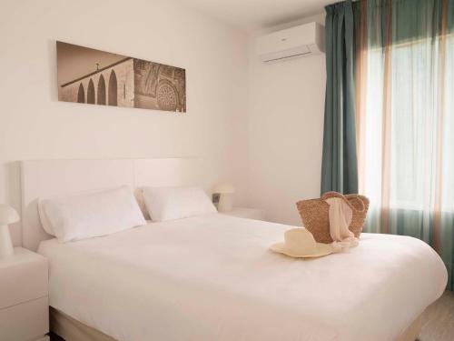 a white bed with a hat on top of it at Aparthotel Ona Aucanada in Port d'Alcudia