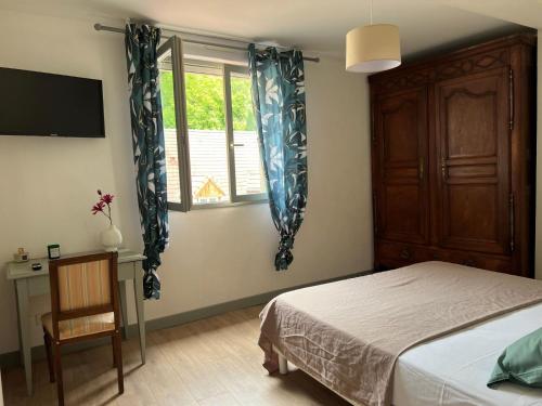 a bedroom with a bed and a window and a chair at G Opératif in Ornans