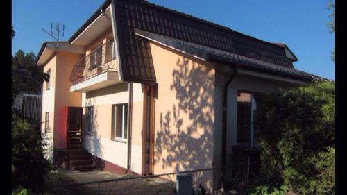 a small house with a porch and a balcony at Butas Prie Nemuno in Druskininkai