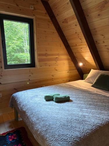 ein Bett in einem Holzzimmer mit Fenster in der Unterkunft Chalet SOFI in Šavnik