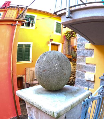 a large rock sitting on a ledge next to a building at Pietra Di Mare in Biassa