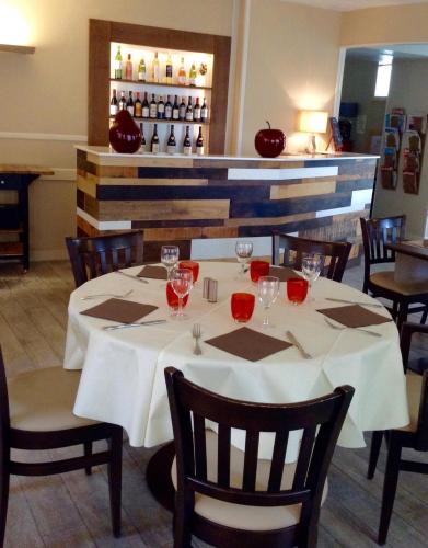 a dining room with a table with wine glasses on it at Hôtel Restaurant de la Place in Saint-Jean-dʼAngély