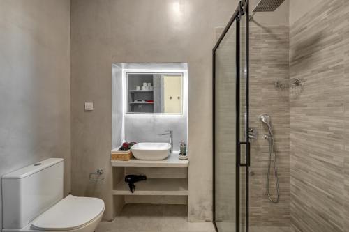 a bathroom with a toilet and a sink and a shower at Garden Residence in Ermoupoli