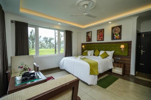 a bedroom with a large white bed and a window at Lumino Winter Castle, Munnar in Pooppara