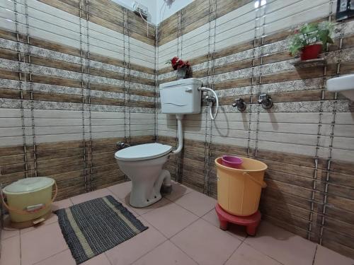 a bathroom with a toilet and two trash cans at The Sanmit Stay Kasauli by Splendid Retreat Hotels in Kasauli