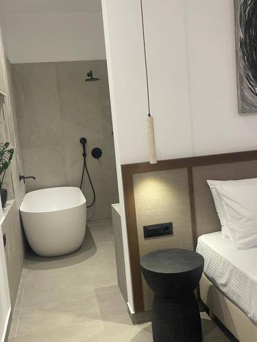 ein Schlafzimmer mit Badewanne, Bett und Tisch in der Unterkunft Villa Yi in Chorafakia