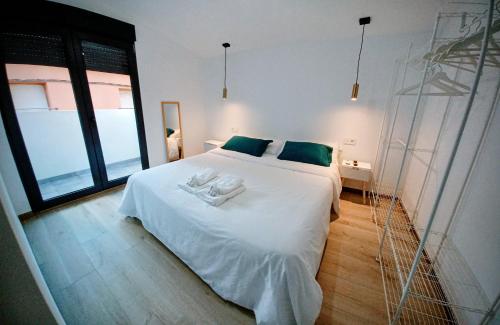 a bedroom with a large white bed with green pillows at Apartamento Turístico La Miranda in Elche de la Sierra