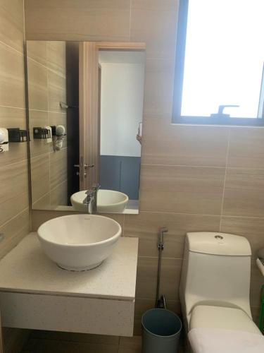 a bathroom with a sink and a toilet and a mirror at ARVO Cam Ranh - Infinity swimming pool in Cam Ranh International Airport