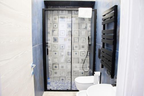 a bathroom with a toilet and a glass shower at Lidi & Miti in Bacoli