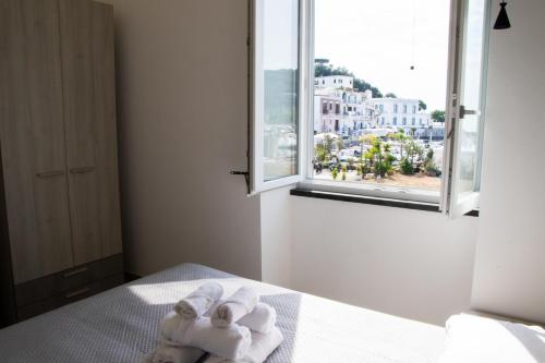 a room with towels on a bed with a window at Lidi & Miti in Bacoli