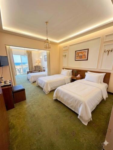 a hotel room with two beds with white sheets at Le Crillon in Broummana