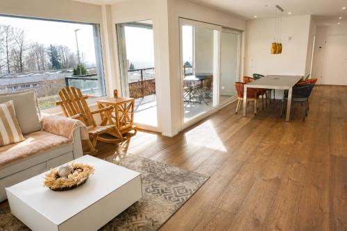 a living room with a couch and a table at Swiss Horizon - Mythenblick - Modern 100m2 mit Alpenblick und Terrassen in Hinwil