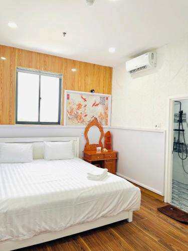 a bedroom with a white bed and a window at Solar Tower in Soc Trang