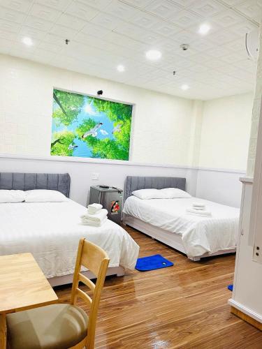 two beds in a room with a tv on the wall at Solar Tower in Soc Trang