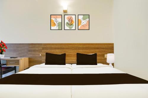 a bedroom with a large white bed and a desk at Super Collection O MG Road in Cochin