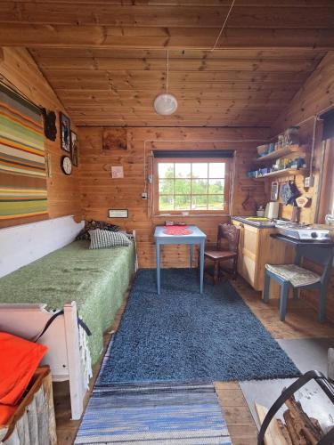 a bedroom in a log cabin with a bed and a desk at Villa Sevettijärvi in Sevettijärvi