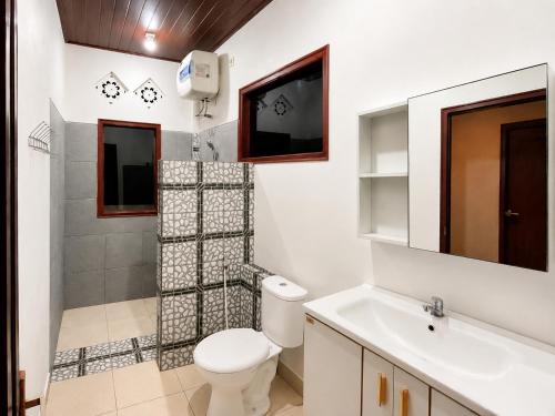 ein weißes Badezimmer mit Toilette und Waschbecken in der Unterkunft Buana Asti Homestay Retreat Batukaru in Tabanan