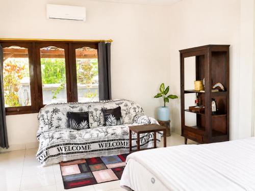 ein Wohnzimmer mit Sofa und Fenster in der Unterkunft Buana Asti Homestay Retreat Batukaru in Tabanan
