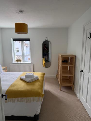 a bedroom with a bed and a window at Pelican House in Bridport