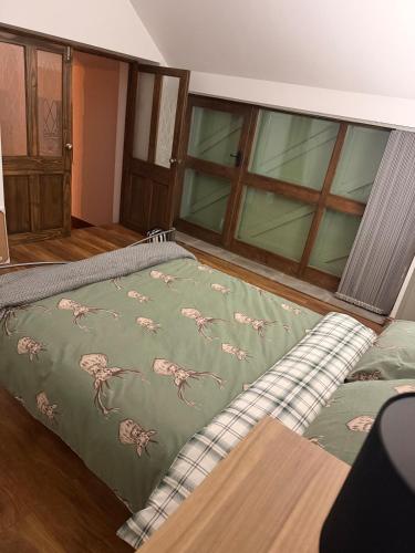 a bedroom with a bed with a blanket on it at The Old Smithy in Langsett