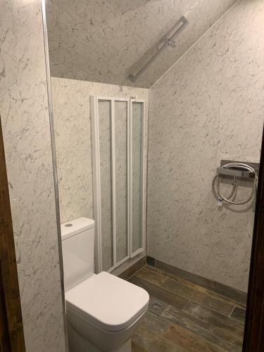 a bathroom with a white toilet in a room at The Old Smithy in Langsett