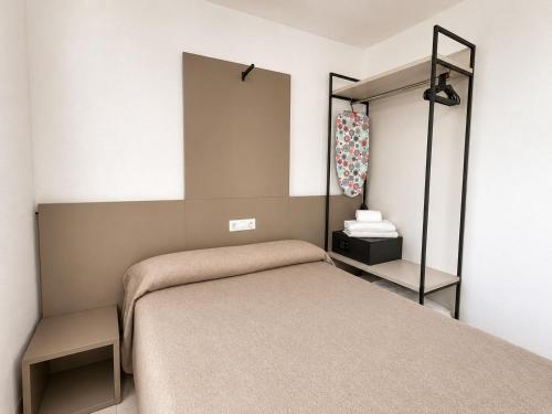 a small bedroom with a bed and a mirror at Apartamentos El Faro By Mc in Benidorm