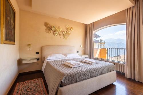 a bedroom with a bed and a large window at IseoLakeRental - Nido Belvedere in Fonteno