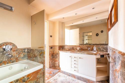 a bathroom with a tub and a sink at IseoLakeRental - Nido Belvedere in Fonteno
