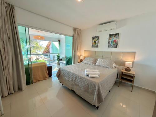 a bedroom with a bed with two towels on it at Brisa de Barra Grande Beach House Pé na Areia in Maragogi