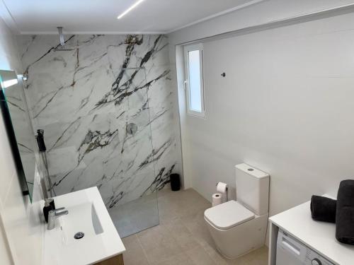 a bathroom with a shower and a toilet and a sink at Apartamentos San Antonio - GrupoAMI in Ontinyent