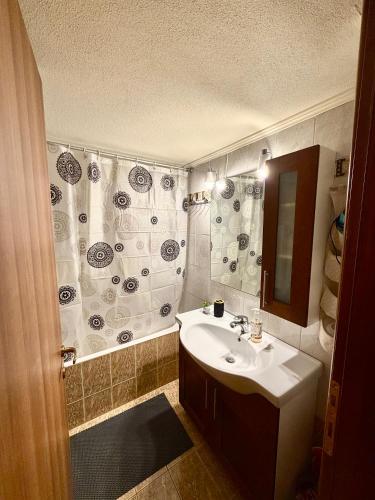 a bathroom with a sink and a shower curtain at Blue Horizon Makri in Alexandroupoli