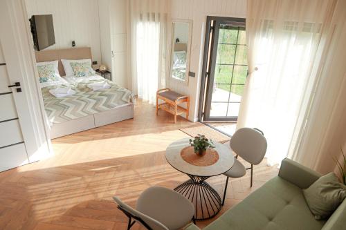 a living room with a bed and a table and chairs at Sakų Apartamentai in Varėna