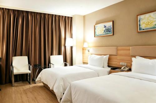 a hotel room with two beds and a window at Dayi Yihao hotel in Xiamen