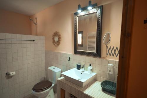 a bathroom with a sink and a toilet and a mirror at Finca Caballo Blanco in Montuiri