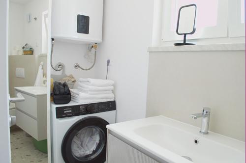a laundry room with a washing machine and a sink at Maslina in Crikvenica
