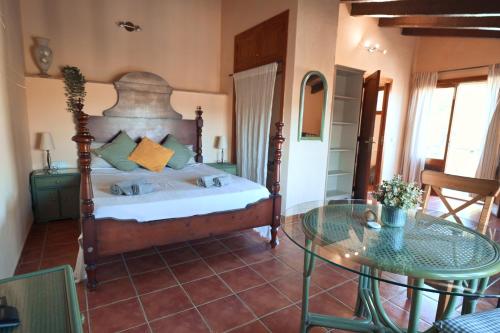 a bedroom with a bed and a glass table at Finca Caballo Blanco in Montuiri