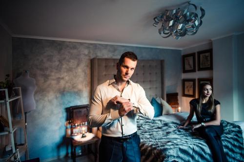 a man standing in a bedroom with a woman sitting on a bed at Luxury Apartments No. 91 in Český Krumlov