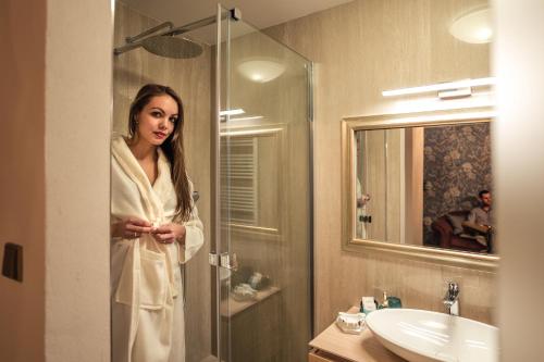 une femme dans une serviette debout dans une salle de bains dans l'établissement Luxury Apartments No. 91, à Český Krumlov