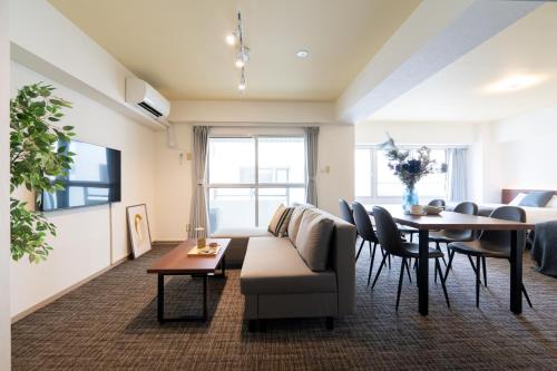 a living room with a couch and a table at Residence Hotel KABUTO Premier in Sapporo