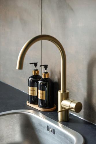 a bathroom sink with two bottles of soap on it at La Nuit Etoilee Balneo Hyper Centre Chalon in Chalon-sur-Saône