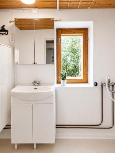 a bathroom with a sink and a tub and a window at Villa Ralli in Jämsä
