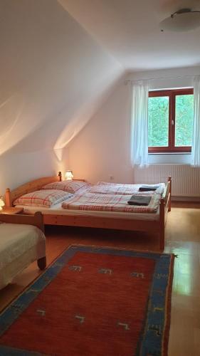 a bedroom with a large bed and a window at Winterberg Vendégház in Óbánya