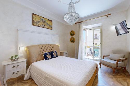 a bedroom with a bed and a chair and a window at B&B Palazzo del Teatro in Agrigento