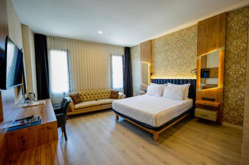 una camera d'albergo con un letto e un divano di Isnova Hotel Airport a Antalya (Adalia)