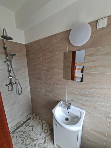 a bathroom with a sink and a shower at Kitti Panzió in Tiszadada