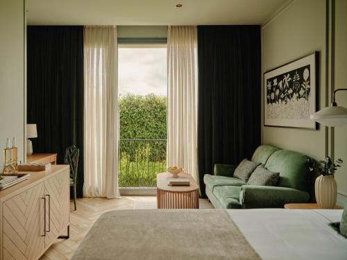 ein Wohnzimmer mit einer grünen Couch und einem Fenster in der Unterkunft Palacio de Luces, Small Luxury Hotels in Luces