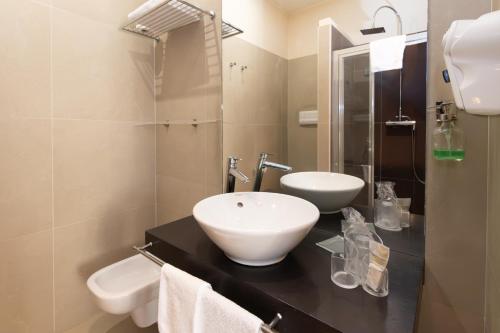 a bathroom with a sink and two toilets on a counter at Resid Enza Palazzo Sciacca in Patti