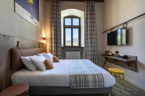 a hotel room with a bed and a window at DAFFY Hôtel in Briançon