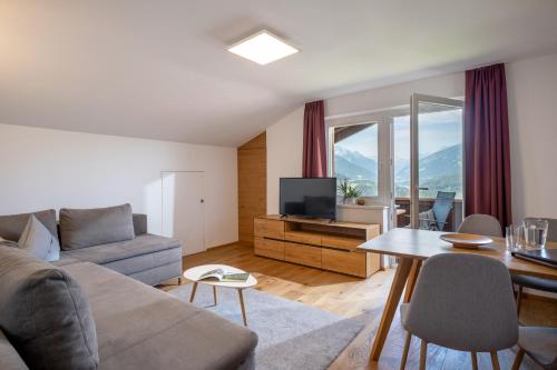 a living room with a couch and a table at Ferienwohnungen Tiroler Alpenhof in Innsbruck