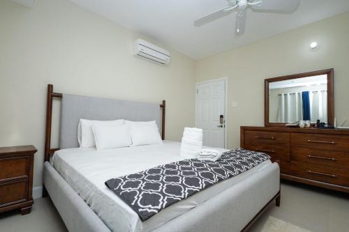 a bedroom with a bed and a dresser and a mirror at Oceanpointe Luxury Retreat in Georgia